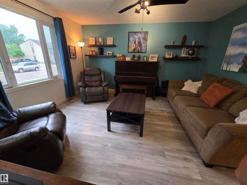 Living area featuring light wood-finish flooring and a ceiling fan with integrated lighting - 2514 149 Avenue, Edmonton, AB 