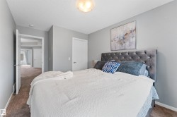 Bedroom featuring light gray walls, textured ceiling, and neutral carpet flooring - 