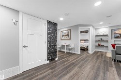 Spacious room featuring wood-finish flooring, recessed lighting, and a contemporary decorative screen - 