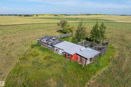 Modest structure with a metal roof surrounded by an expansive, undeveloped landscape - 534072 Range Road 85, Rural Two Hills County, AB 