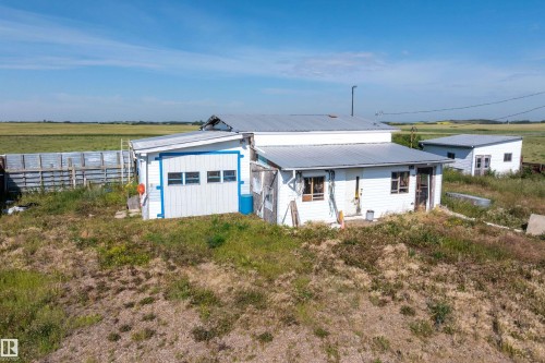 Outbuilding featuring white siding and blue trim, with a metal roof and three horizontal windows - 534072 Range Road 85, Rural Two Hills County, AB 
