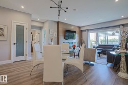 Open-concept living space featuring wood-finish flooring, recessed lighting, and a modern chandelier - 