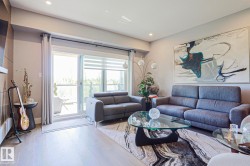 Open-concept living space with light wood-finish flooring, recessed lighting, and a neutral color palette - 