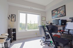 Bright room with a large window, light gray walls, white trim, and light-colored carpet flooring - 