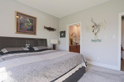 Carpeted bedroom featuring a dark wood-finish headboard and light gray wall paint - 