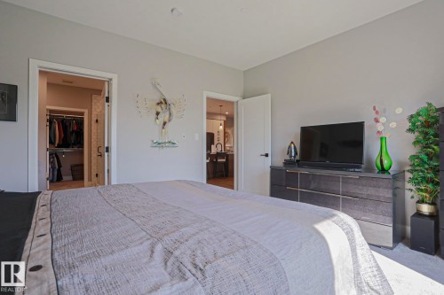 Bedroom featuring a walk-in closet with built-in storage and a private doorway to an additional room - 211 7463 May Common, Edmonton, AB 