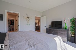 Bedroom featuring a walk-in closet with built-in storage and a private doorway to an additional room - 