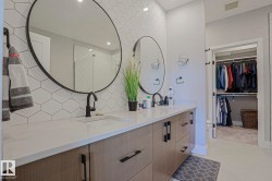 Double vanity with white countertop, dual undermount sinks, and matte black fixtures - 