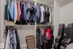 Custom-built closet system featuring multiple hanging rods and integrated shelving for organized storage - 