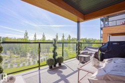 Spacious covered balcony featuring a glass railing, wood-finish ceiling, and durable tile flooring - 