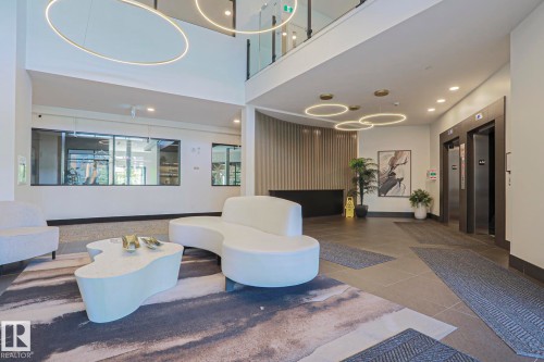 Grand lobby entrance featuring high ceilings and contemporary circular pendant lighting - 211 7463 May Common, Edmonton, AB 