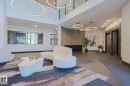 Grand lobby entrance featuring high ceilings and contemporary circular pendant lighting - 211 7463 May Common, Edmonton, AB 