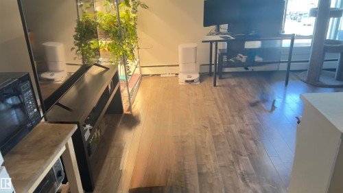 Wood-finish flooring throughout, featuring a natural grain and varied tones - 311 8604 Gateway Boulevard, Edmonton, AB 