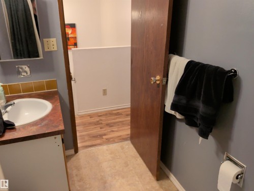 Vanity featuring a white basin sink, polished chrome faucet, and brown countertop - 2724 105 Street Nw, Edmonton, AB - Indoor Photo Showing Bathroom