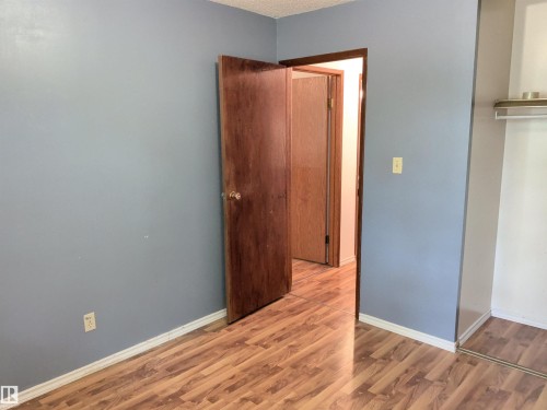 Wood-finish flooring throughout, complemented by a light blue wall color - 2724 105 Street Nw, Edmonton, AB - Indoor Photo Showing Other Room