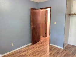 Wood-finish flooring throughout, complemented by a light blue wall color - 