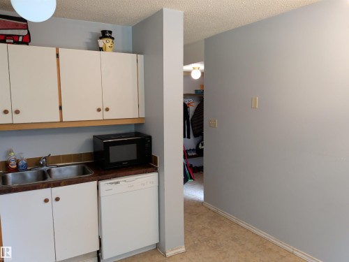 Kitchen area featuring white cabinetry, a double basin sink, and an integrated dishwasher - 2724 105 Street Nw, Edmonton, AB - Indoor Photo Showing Kitchen With Double Sink