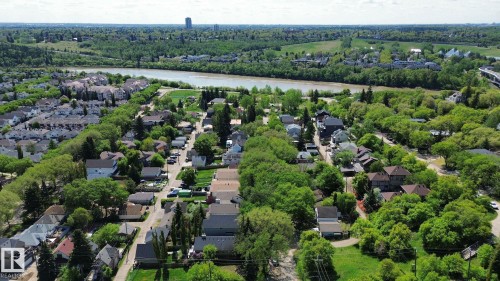 Aerial perspective showcasing a residential area with mature trees and a riverfront setting - 10173 93 Street, Edmonton, AB 