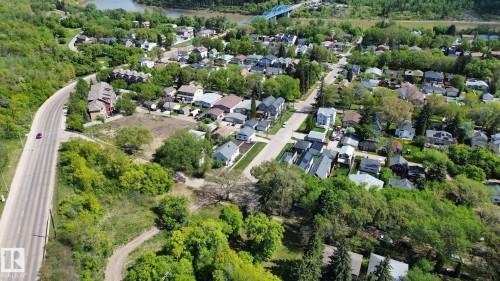 Aerial perspective showcasing a residential area with varied housing styles, mature trees, and a prominent roadway - 10173 93 Street, Edmonton, AB 
