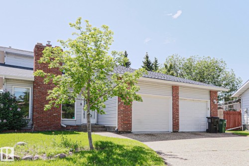 Two-car garage with white doors, brick accents, and light-colored siding - 17811 62C Avenue, Edmonton, AB 