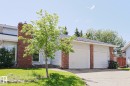 Two-car garage with white doors, brick accents, and light-colored siding - 17811 62C Avenue, Edmonton, AB 
