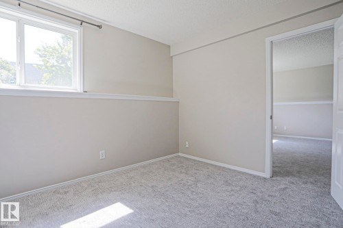 Carpeted room with neutral wall tones and white baseboards - 17811 62C Avenue, Edmonton, AB 