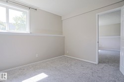 Carpeted room with neutral wall tones and white baseboards - 