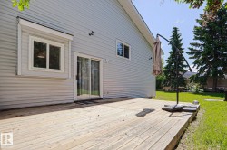 Expansive wood deck with a white vinyl siding exterior - 