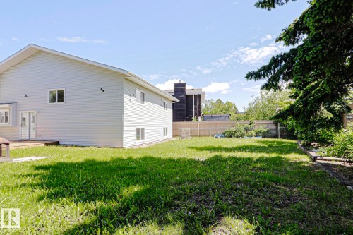 Expansive grassy yard with mature tree coverage and a partial wood fence - 17811 62C Avenue, Edmonton, AB 