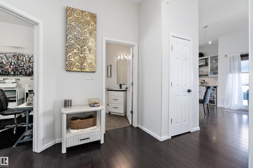 Hall featuring a desk, dark wood-style flooring, and beverage cooler - 302 10905 109 Street, Edmonton, AB 