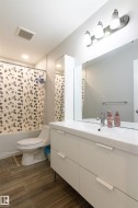 Contemporary bathroom featuring a white vanity with integrated sink, chrome faucet, and mirrored wall cabinet - 