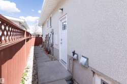 White stucco exterior with a side entry door featuring a glass-paned insert - 