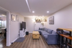 Spacious living area featuring recessed lighting, wood-finish flooring, and light-toned walls - 