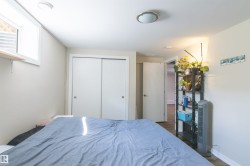 Room featuring wood-finish flooring, a flush-mount ceiling light fixture, a window with horizontal blinds, and double sliding closet doors - 