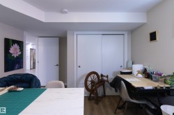 Recessed lighting illuminates an interior room featuring wood-finish flooring, a white sliding closet door, and a white interior door - 
