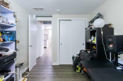 Interior hallway with wood-finish flooring, white walls, and white trim - 