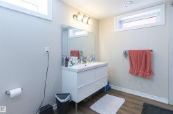 Modern bathroom featuring a white floating vanity with an integrated sink and storage drawers - 