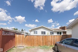 Private yard space featuring a wood fence, red lattice top fence, and a gate - 