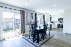 Open-concept dining area featuring wood-finish flooring, recessed lighting, and a sliding glass door to a back deck - 