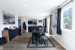 Open-concept living space featuring wood-finish flooring, recessed lighting, and ample natural light from multiple windows - 