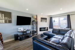 Living area with wood-finish flooring, recessed lighting, and a prominent window - 