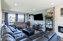 Living area featuring wood-finish flooring, recessed lighting, and a wall-mounted television - 