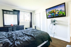 Bedroom featuring wood-finish flooring, a white ceiling, and light-colored walls - 