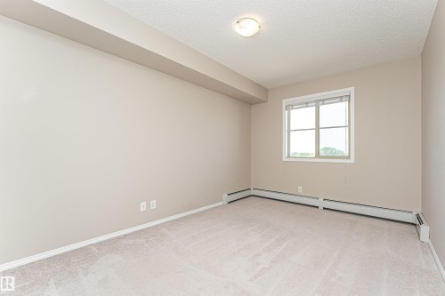 Light-colored carpeted flooring with neutral wall paint - 404 12045 22 Avenue, Edmonton, AB 