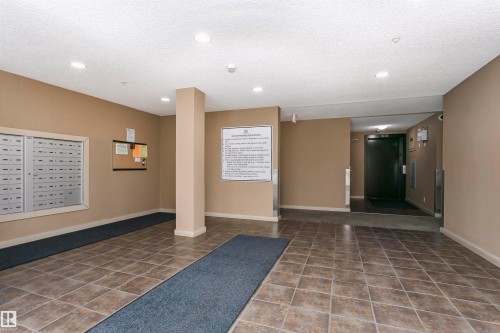 Building foyer featuring tile flooring, neutral wall tones, recessed lighting, and individual mailboxes - 404 12045 22 Avenue, Edmonton, AB 