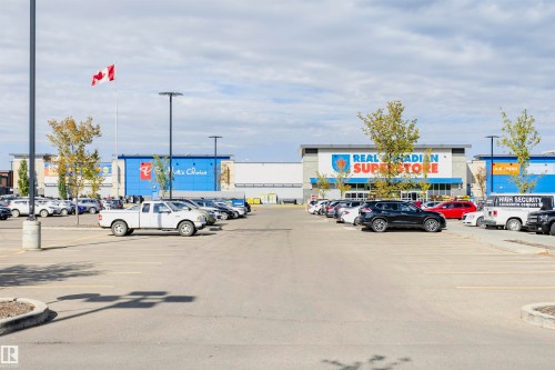 Expansive asphalt parking lot with multiple vehicle spaces - 404 12045 22 Avenue, Edmonton, AB 