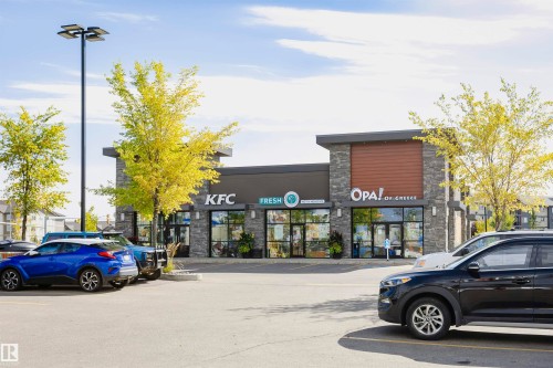 Modern commercial building with stone facade accents and wood-finish paneling - 404 12045 22 Avenue, Edmonton, AB 