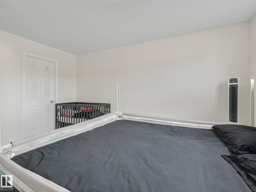 Room featuring light-colored walls and a textured ceiling - 18 230 Edwards Drive, Edmonton, AB 