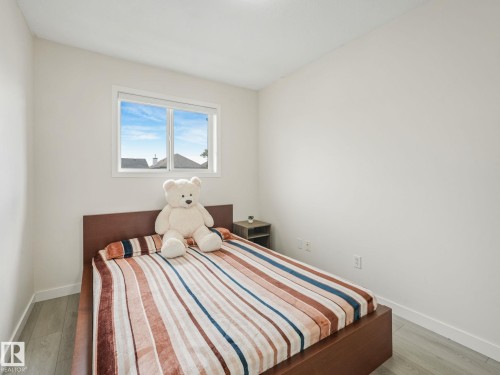 Room with light grey wood-finish flooring and a white window frame - 18 230 Edwards Drive, Edmonton, AB 