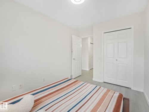 Room featuring light gray wood-finish flooring, white walls, and a ceiling-mounted light fixture - 18 230 Edwards Drive, Edmonton, AB 